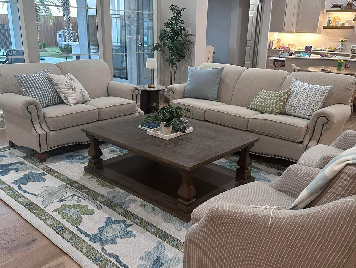 Green and blue area rug in a cozy living room, adding color and warmth for a summer-to-fall home decor transition.