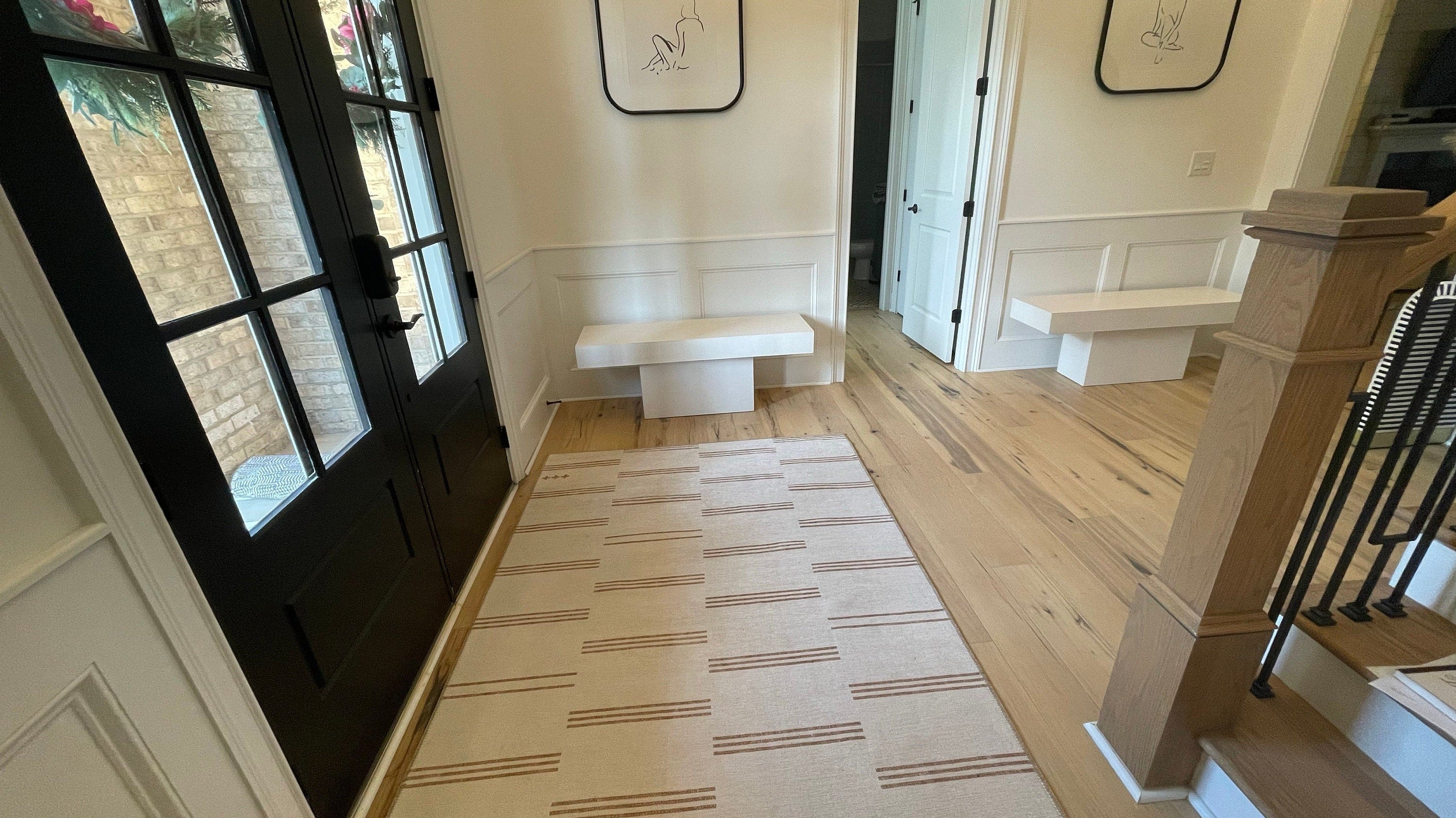 Beige area rug in a neutral modern entryway creating a fresh and welcoming first impression