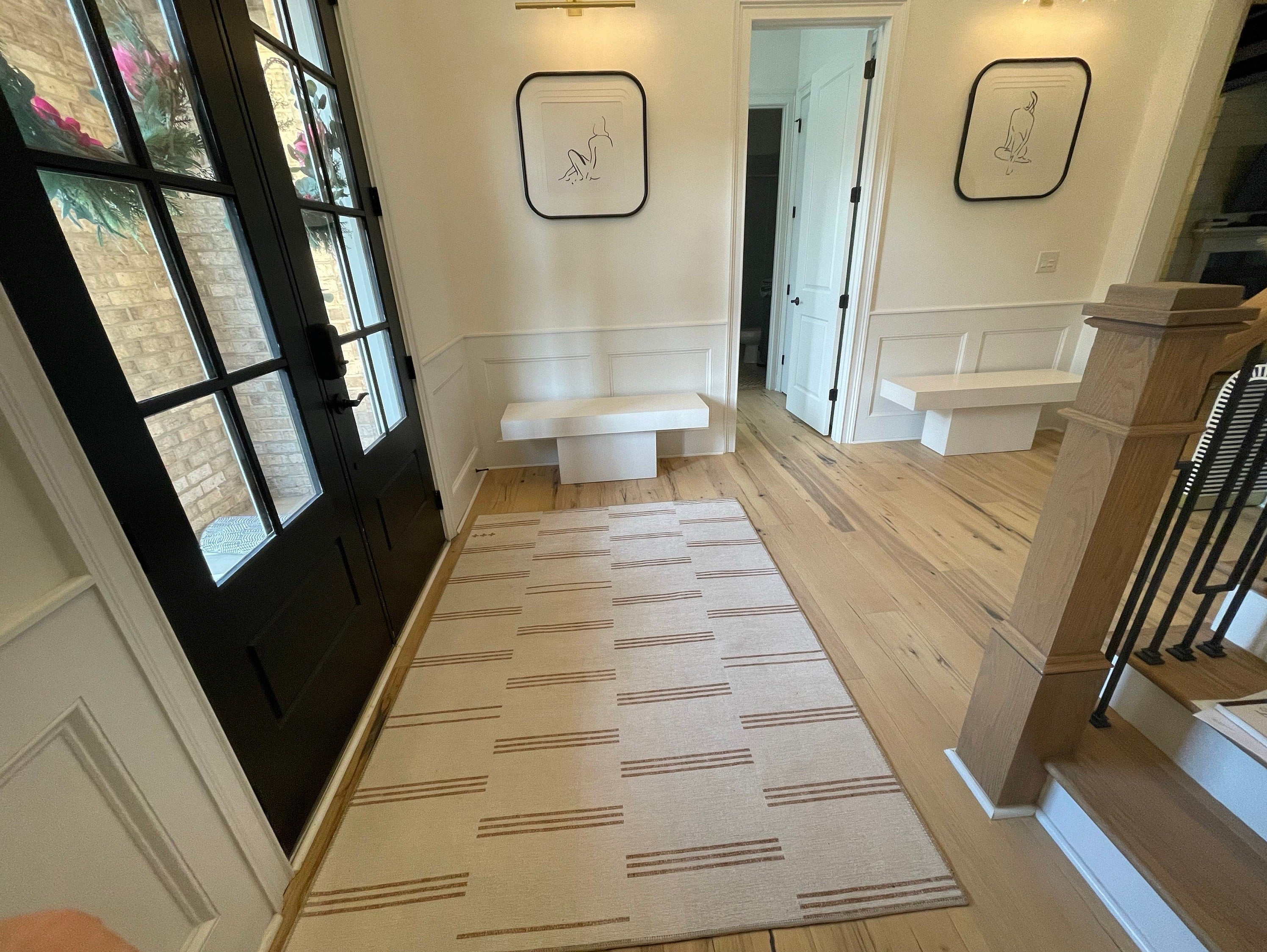 Beige area rug in a neutral modern entryway creating a fresh and welcoming first impression