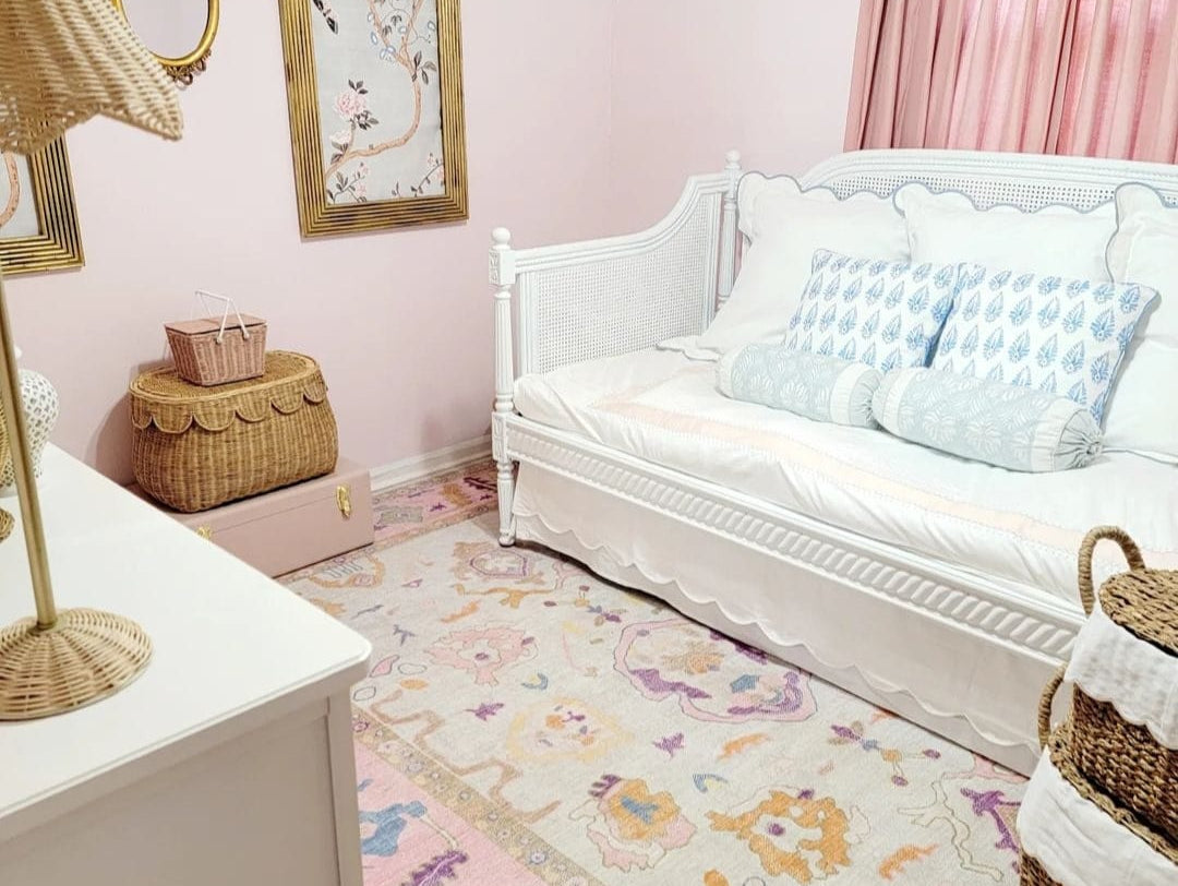 Soft and serene nursery featuring a delicate pink Oushak rug, adding warmth, charm, and a vintage touch to the cozy space.