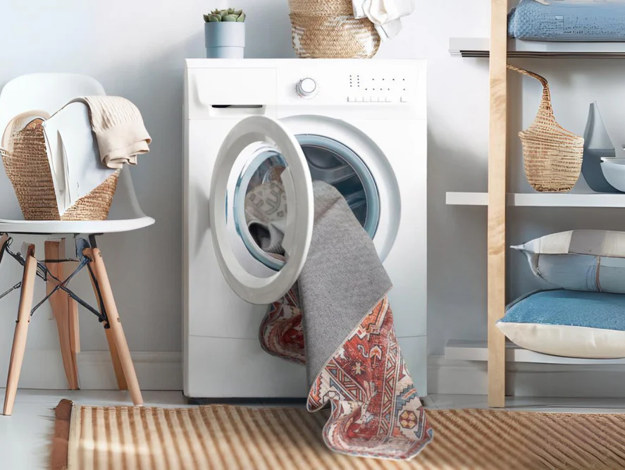 Area rug being washed in a front-loading washing machine with cold waterβan easy, at-home cleaning method recommended for washable rugs from Fame Rugs.