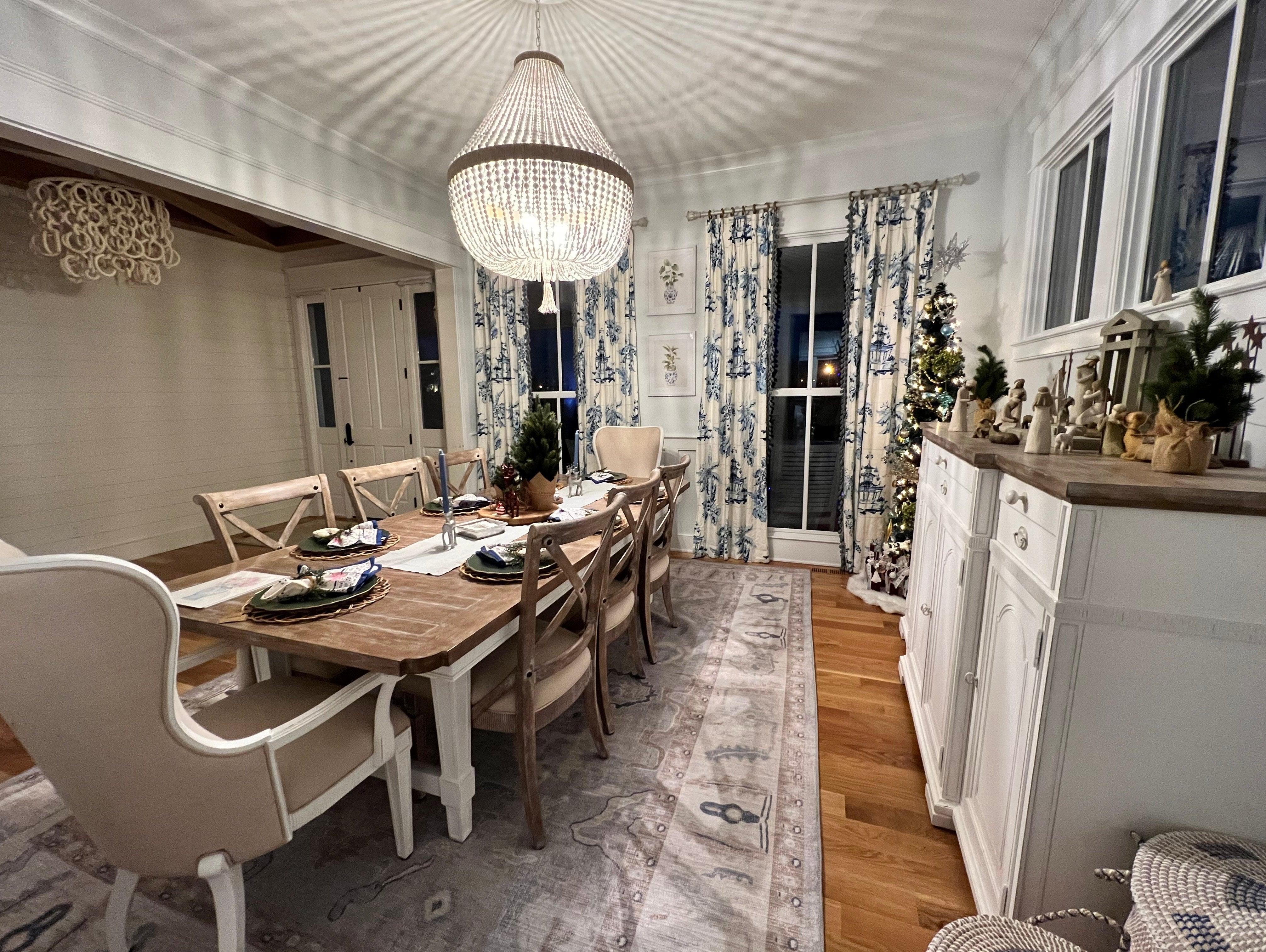 Elegant Modern dining room rug with a subtle pattern, placed under a wooden dining table and chairs to anchor the space and add warmth and style.