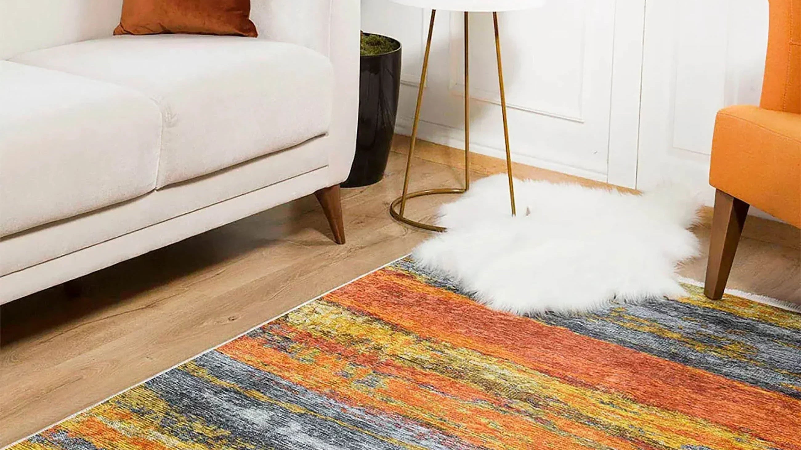 Ochre area rug adding warmth and color to a minimalist living room with beige furniture.