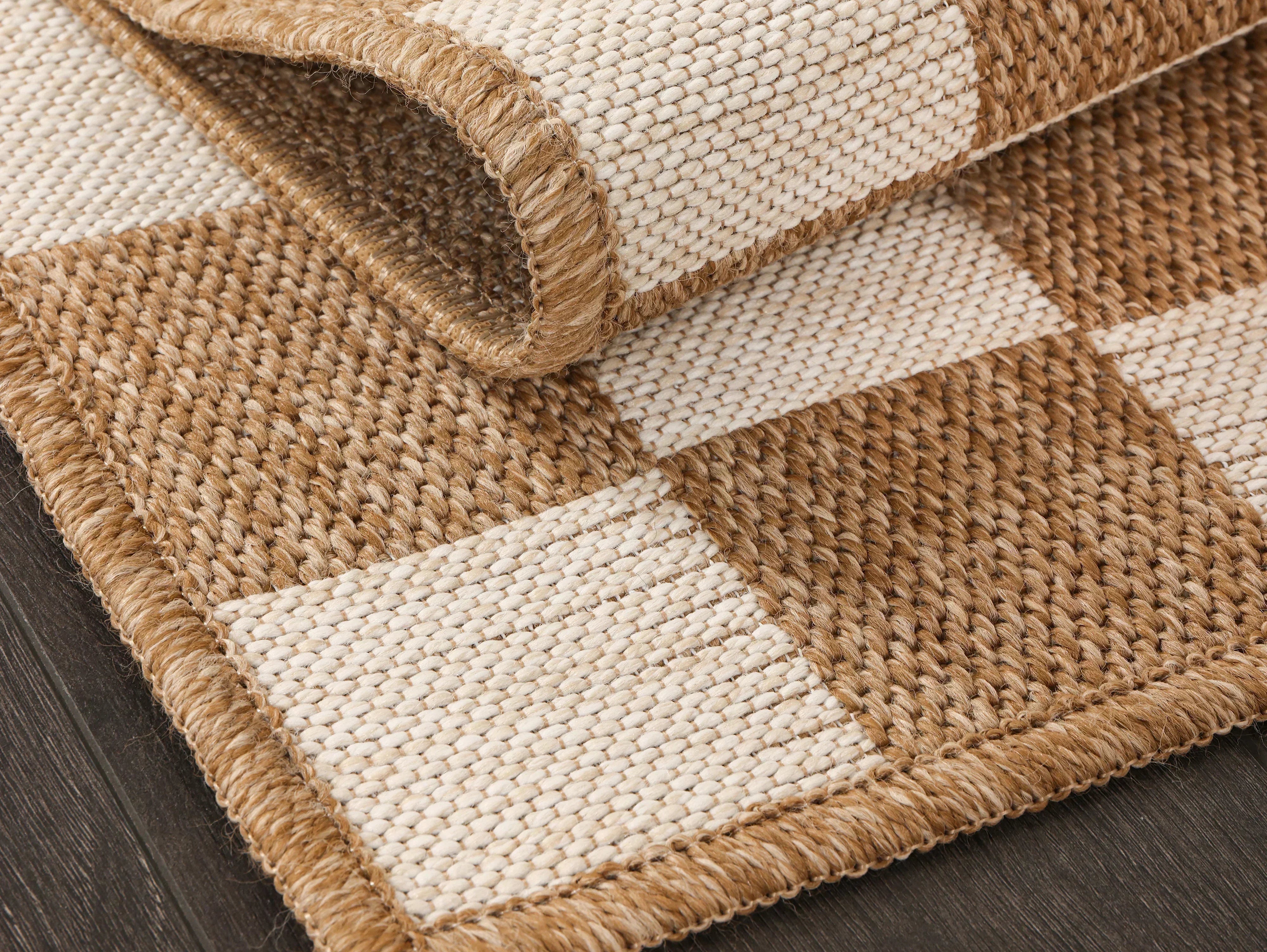 Close-up of a beige checkered textured area rug adding warmth and dimension to neutral home decor.