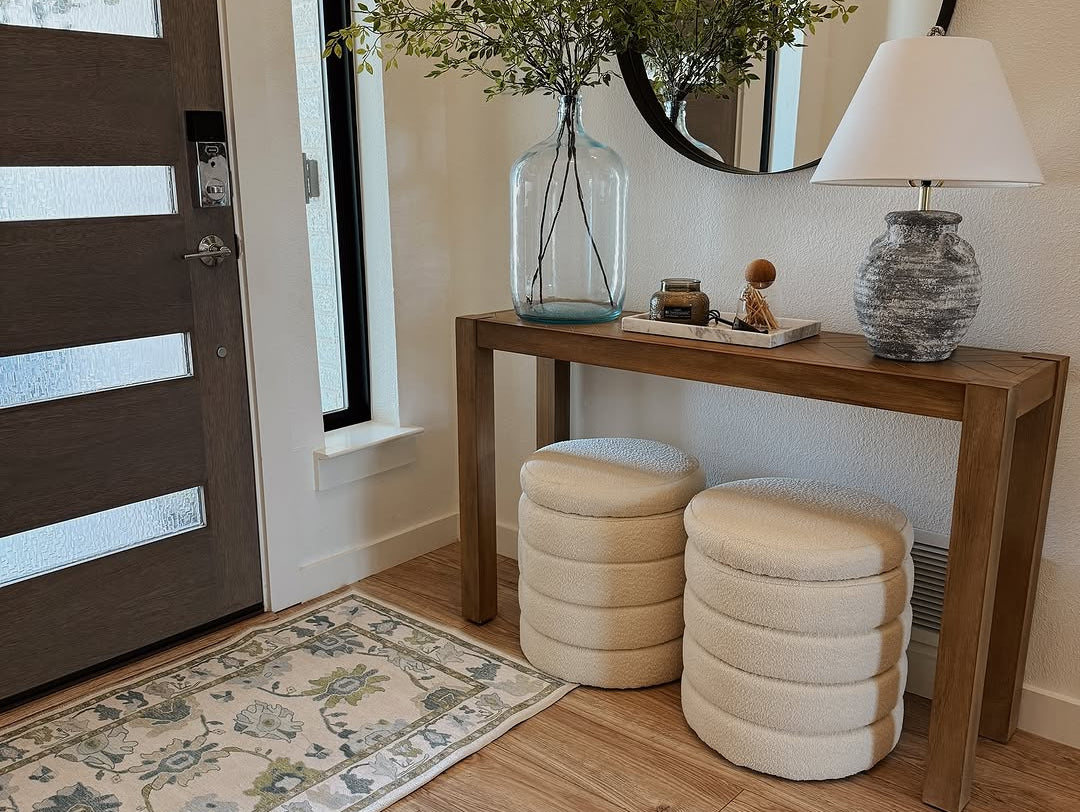 Neutral entryway with a green and blue floral Oushak rug adding soft color and vintage charm