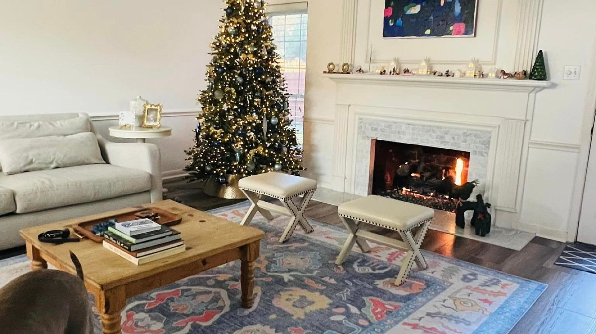Festive living room with cozy Christmas dΓ©cor and a winter-inspired rug.