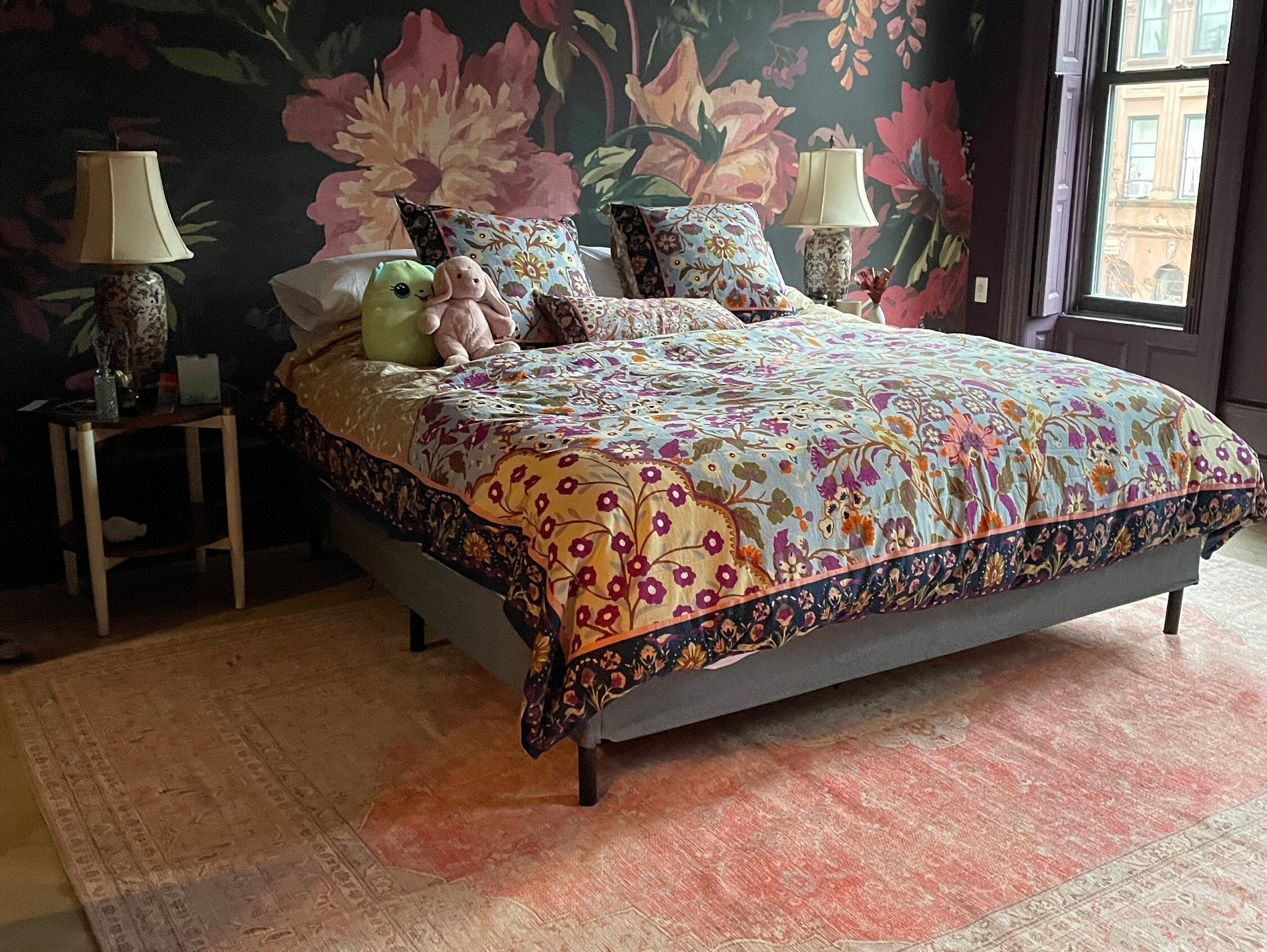 Bedroom with an orangish blush area rug creating a warm, cozy, and hotel-inspired atmosphere