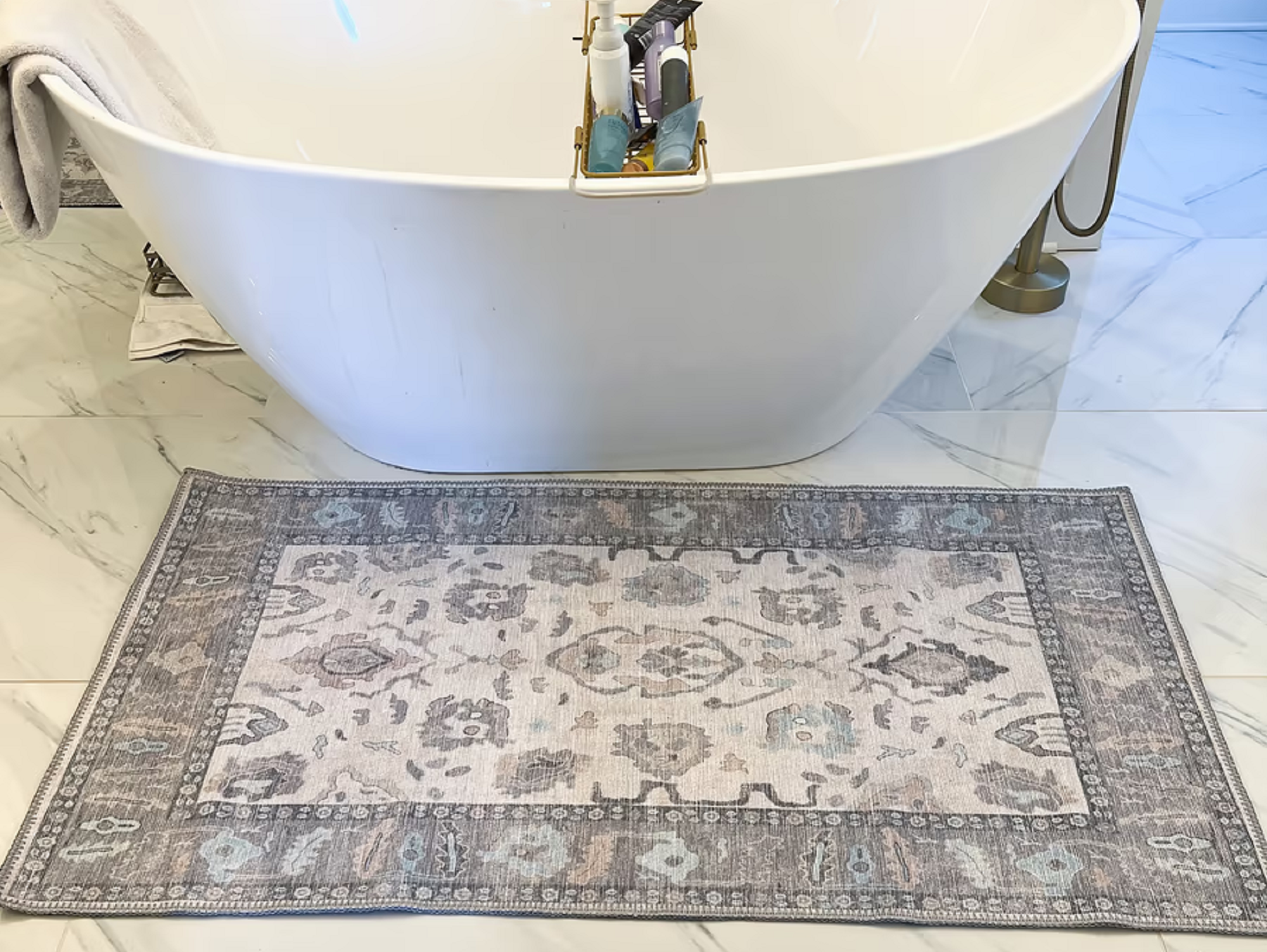 Minimalist bathroom with a sleek gray rug placed beside the bathtub, adding a clean and modern touch to the neutral-toned space.