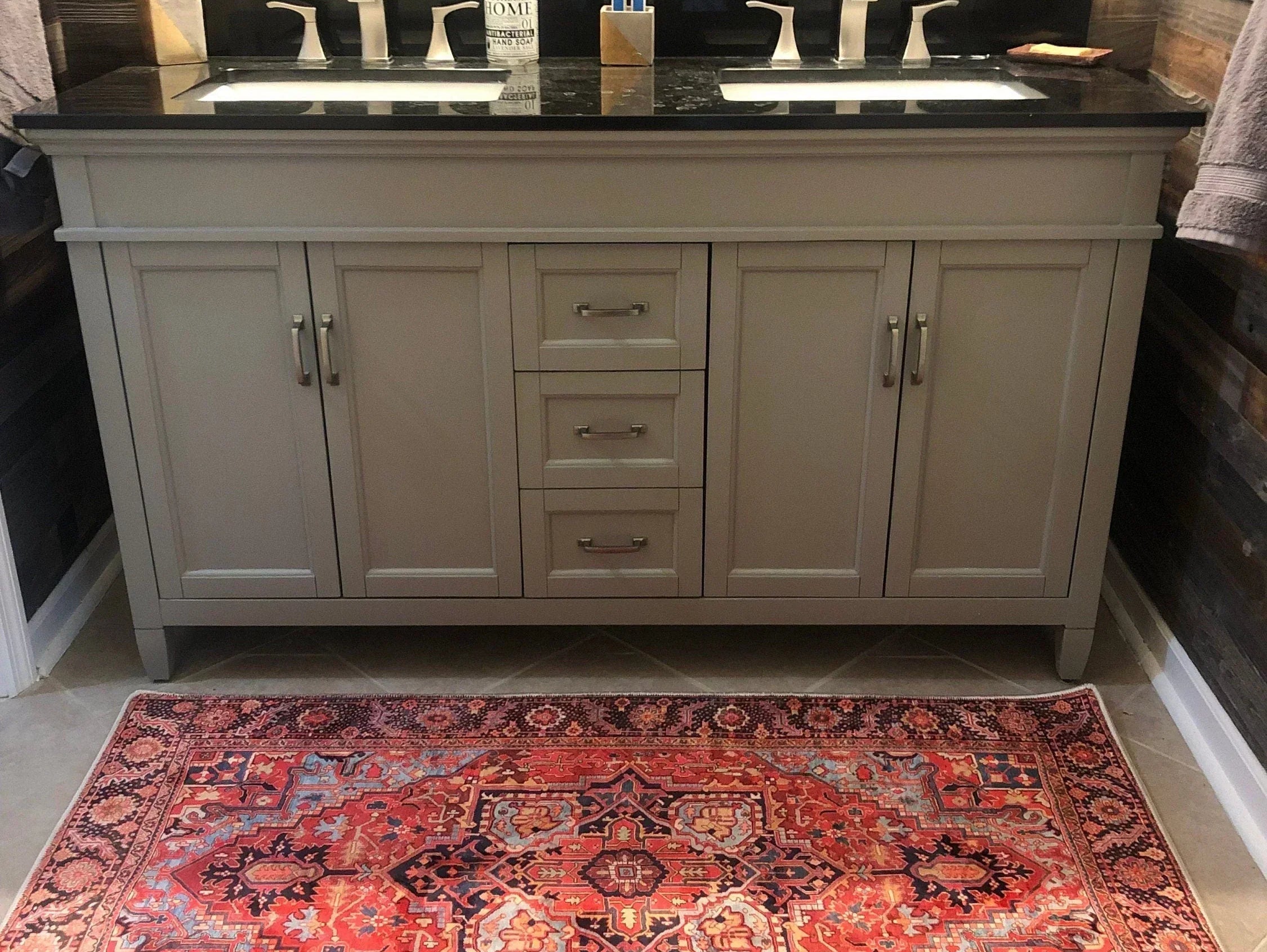 Modern bathroom styled with a bold washable red rug adding a vibrant pop of color against neutral tiles and fixtures.