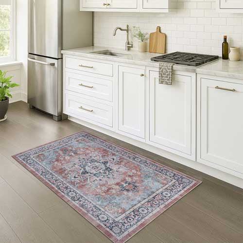 Decorative rug on a kitchen floor with white cabinets and appliances. French Country Rugs - Fame Rugs.