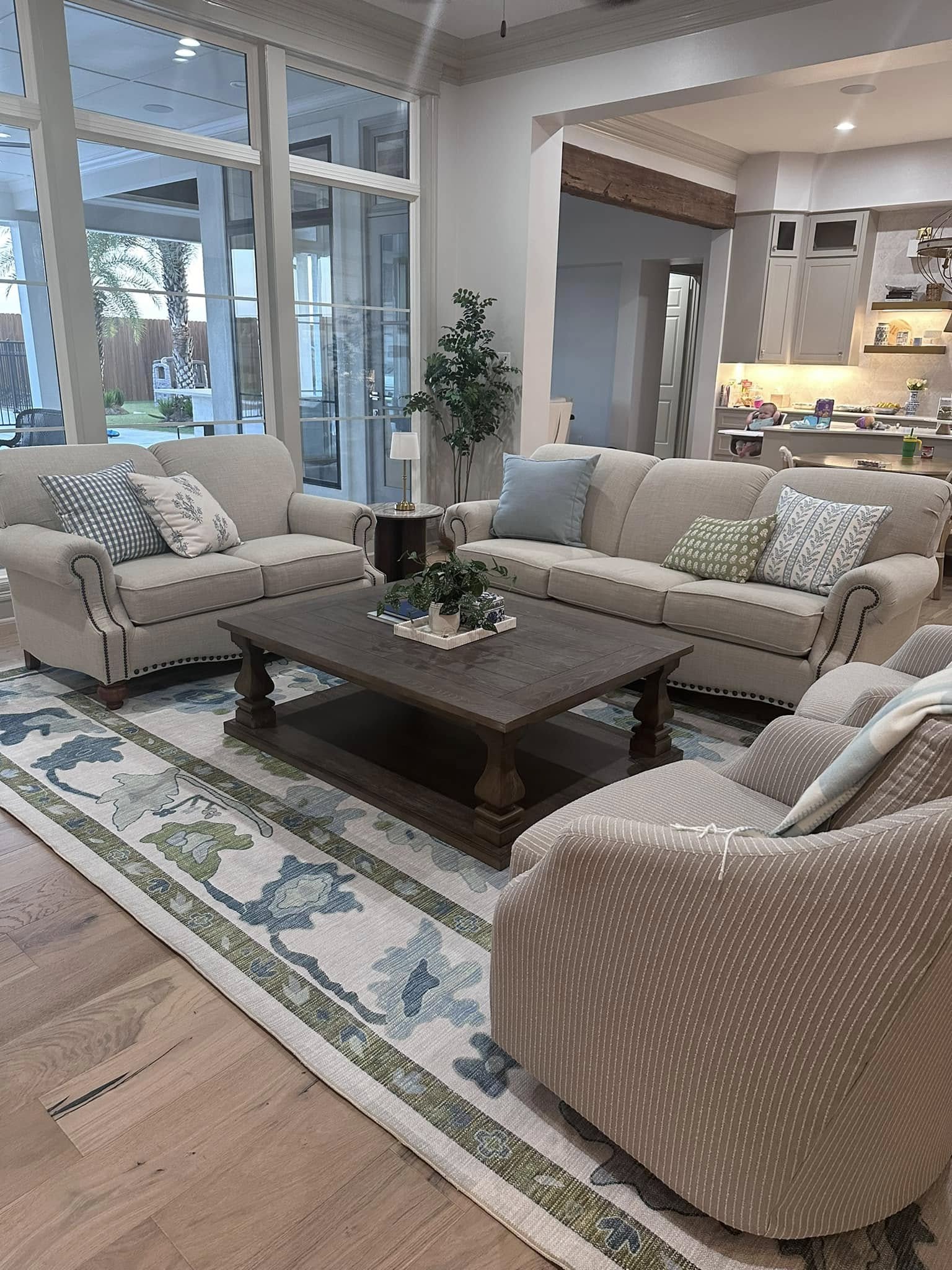 Green and blue area rug in a cozy living room, adding color and warmth for a summer-to-fall home decor transition.