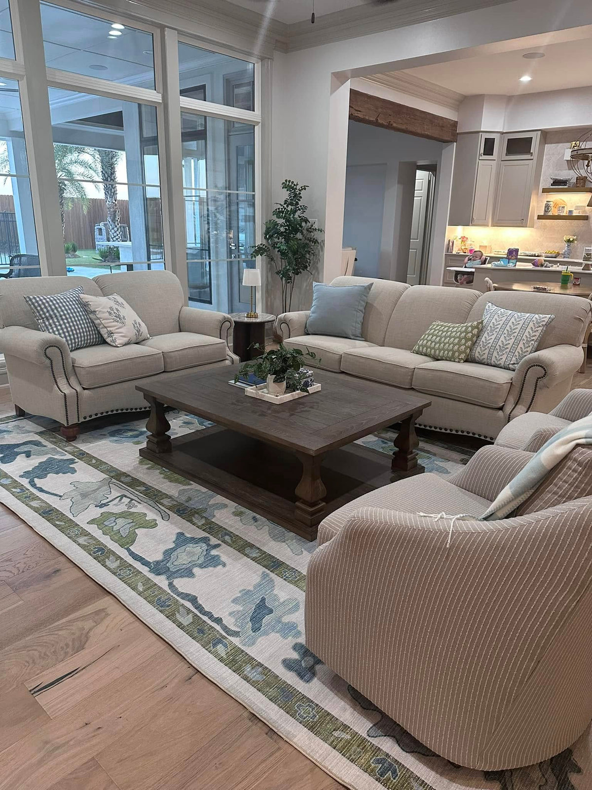 Green and blue area rug in a cozy living room, adding color and warmth for a summer-to-fall home decor transition.