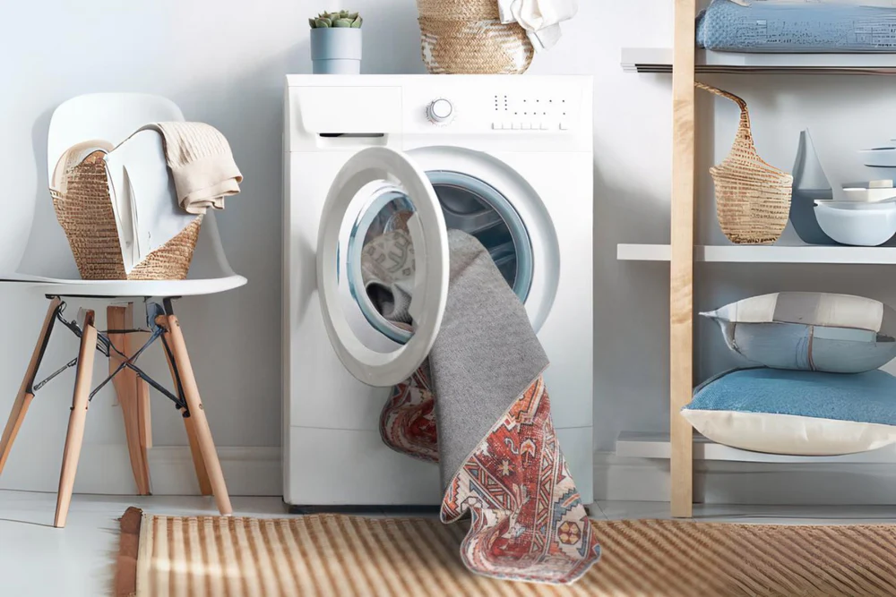 Area rug being washed in a front-loading washing machine with cold water—an easy, at-home cleaning method recommended for washable rugs from Fame Rugs.