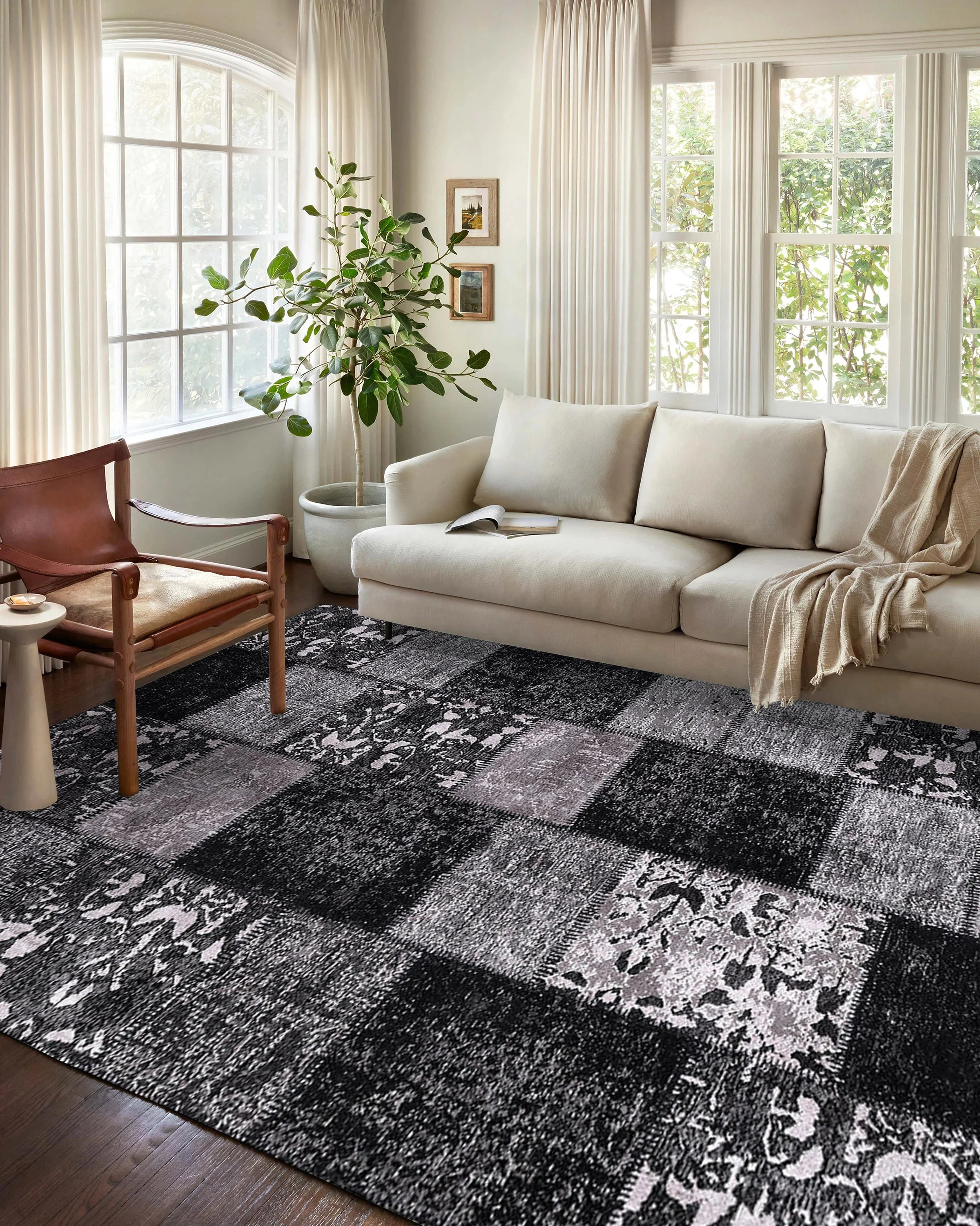 A modern living room styled with a black and white rug, featuring minimalist furniture and monochrome décor elements.