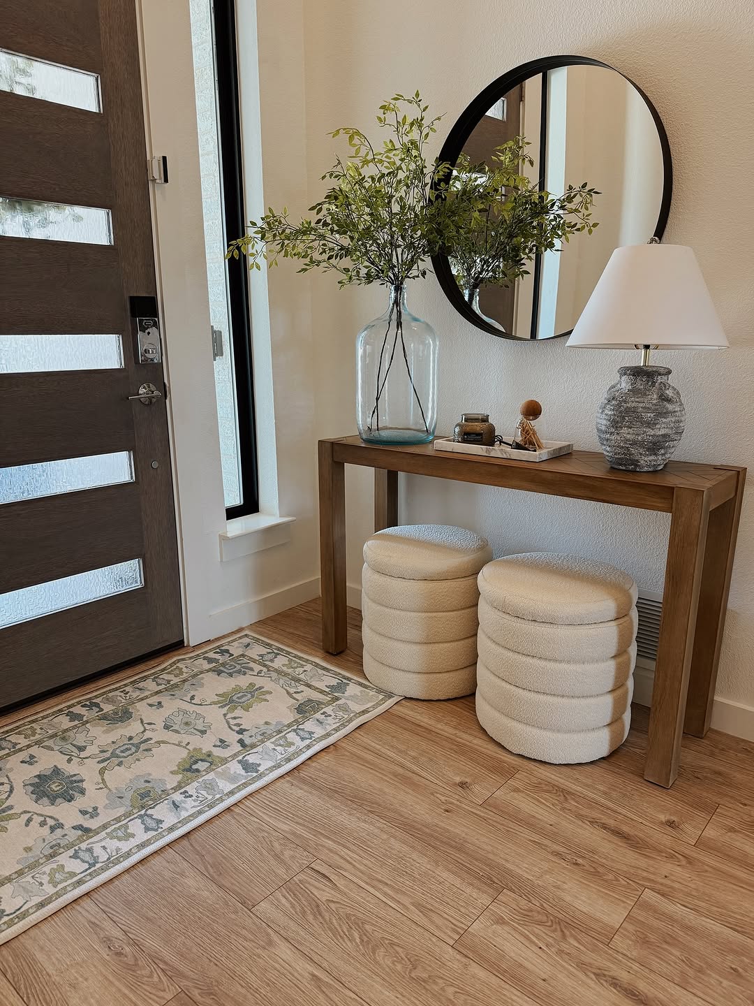 Neutral entryway with a green and blue floral Oushak rug adding soft color and vintage charm