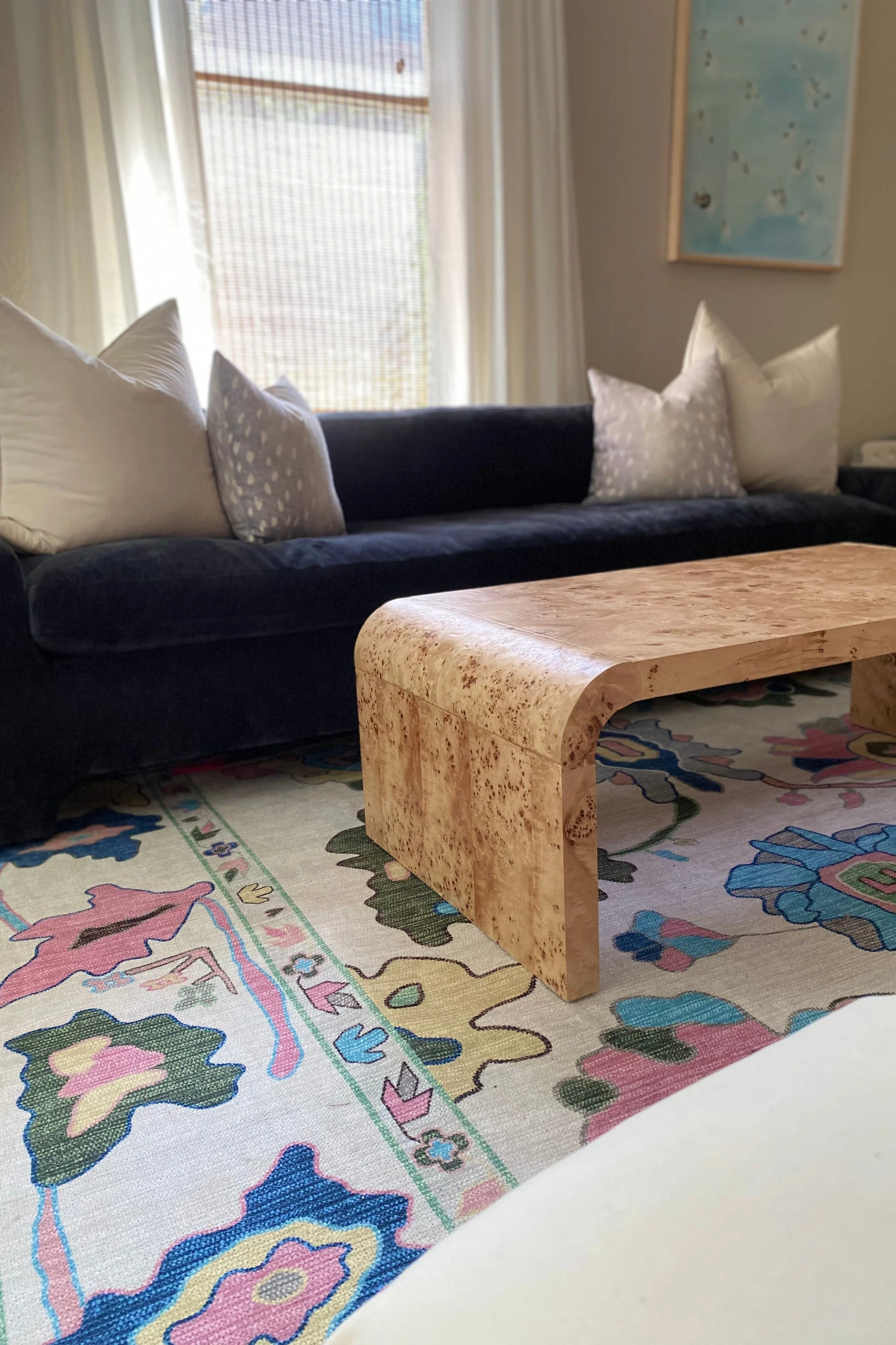 Living room decorated with a bold patterned rug layered alongside a minimalist neutral rug, creating a balanced and stylish interior.