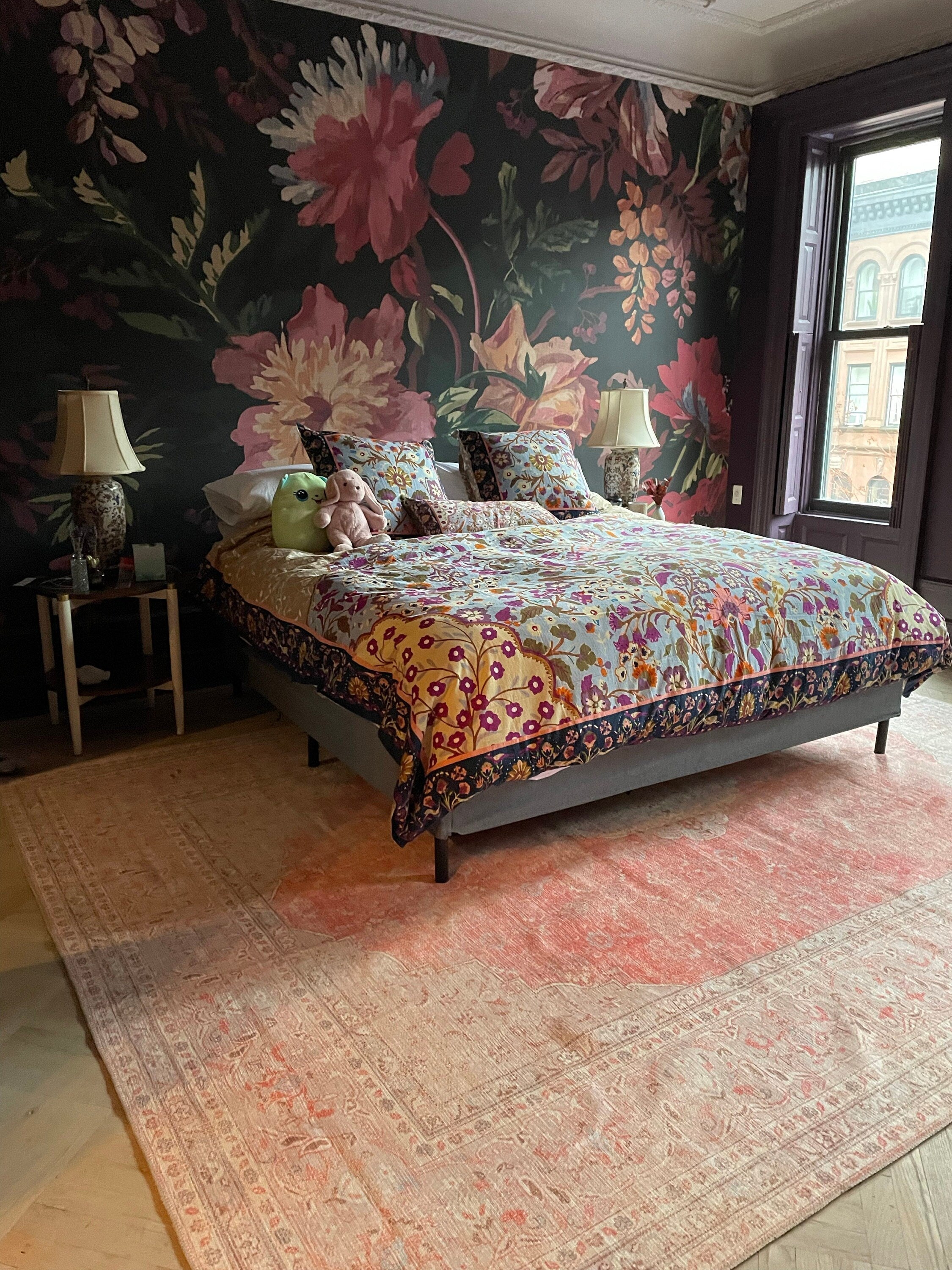 Bedroom with an orangish blush area rug creating a warm, cozy, and hotel-inspired atmosphere