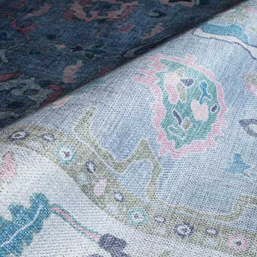 Close-up of patterned fabric with intricate designs in blue, green, and pink. Aviana Pastel Lavender Modern Oushak Rugs - Fame Rugs