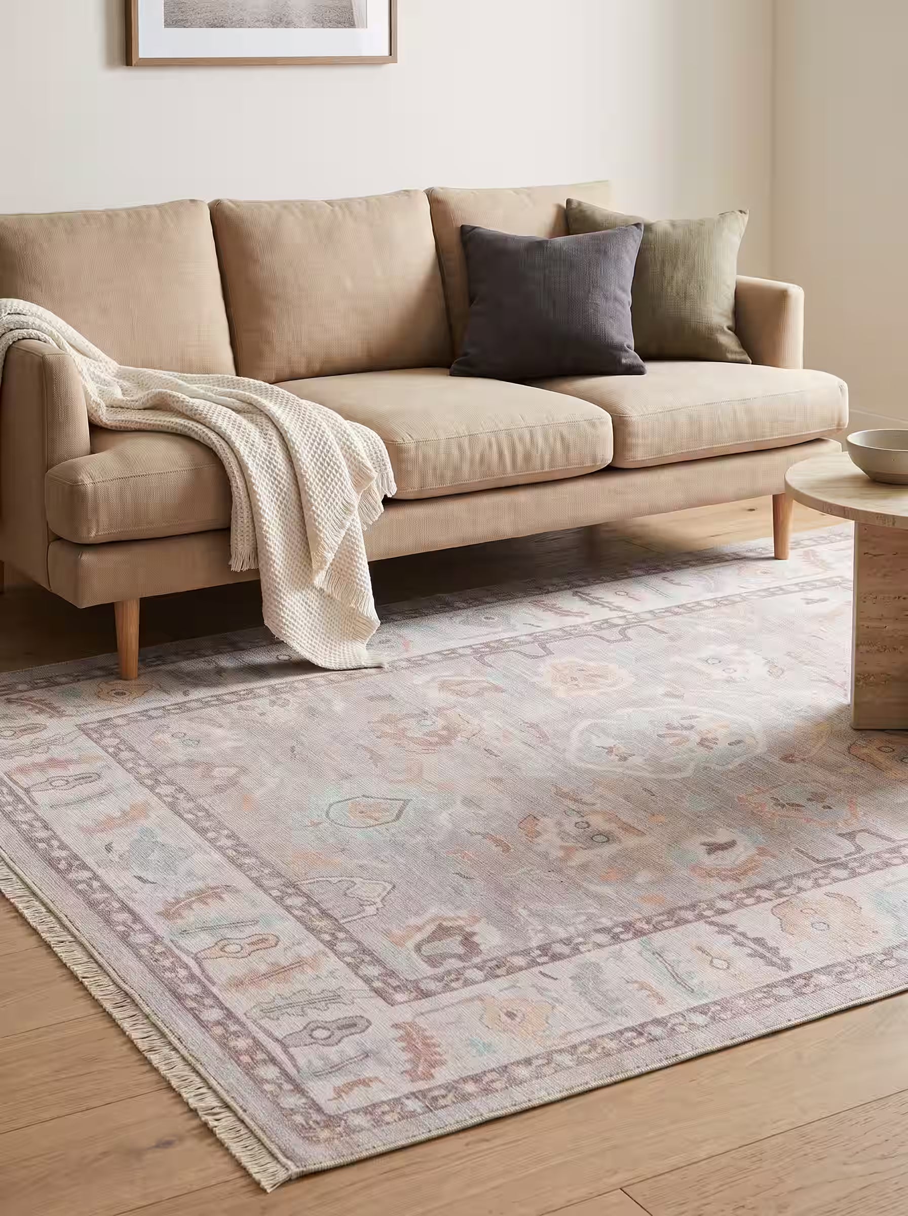 Ivory and greige area rug paired with a beige linen sofa in a modern living room