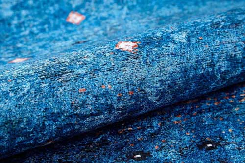 Close-up of blue textured fabric with metallic specks. Blue Rugs - Fame Rugs