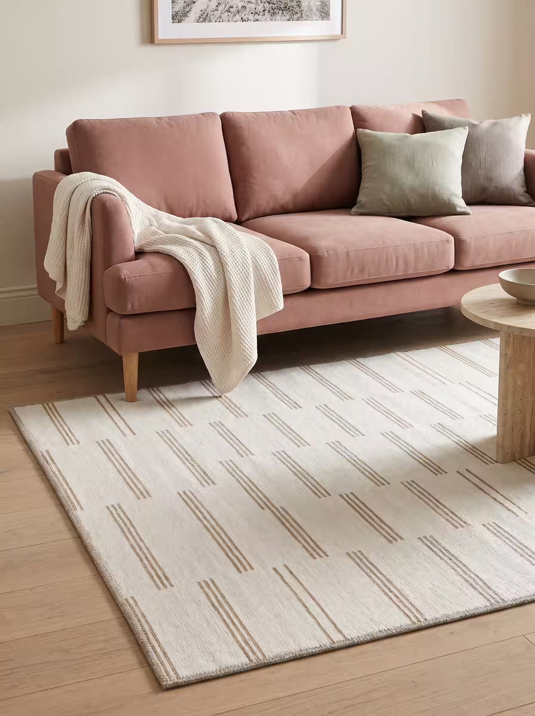 Ivory and greige area rug paired with a blush pink sofa in a modern living room