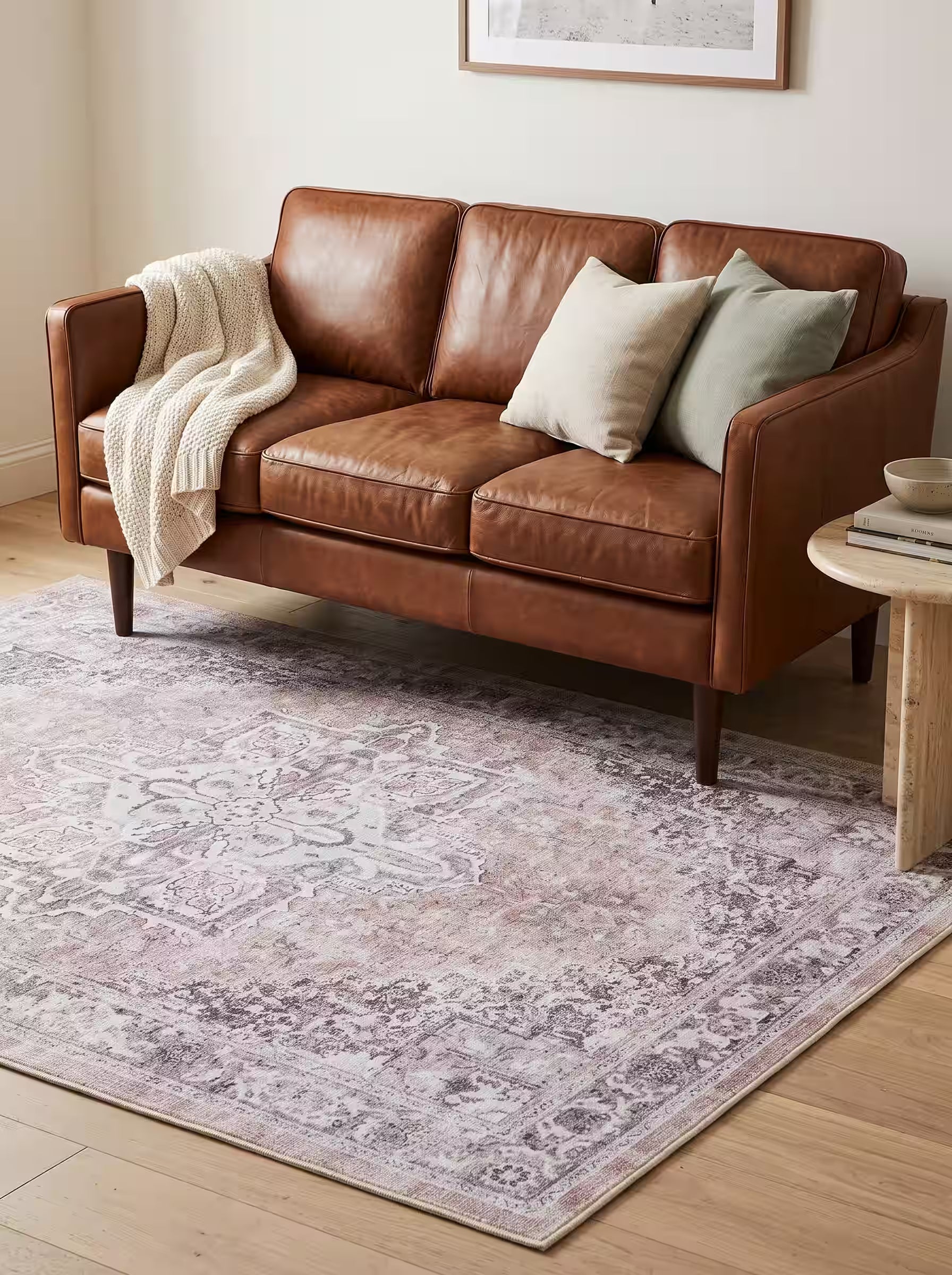 Cream and oatmeal area rug paired with a cognac brown leather sofa in a modern living room