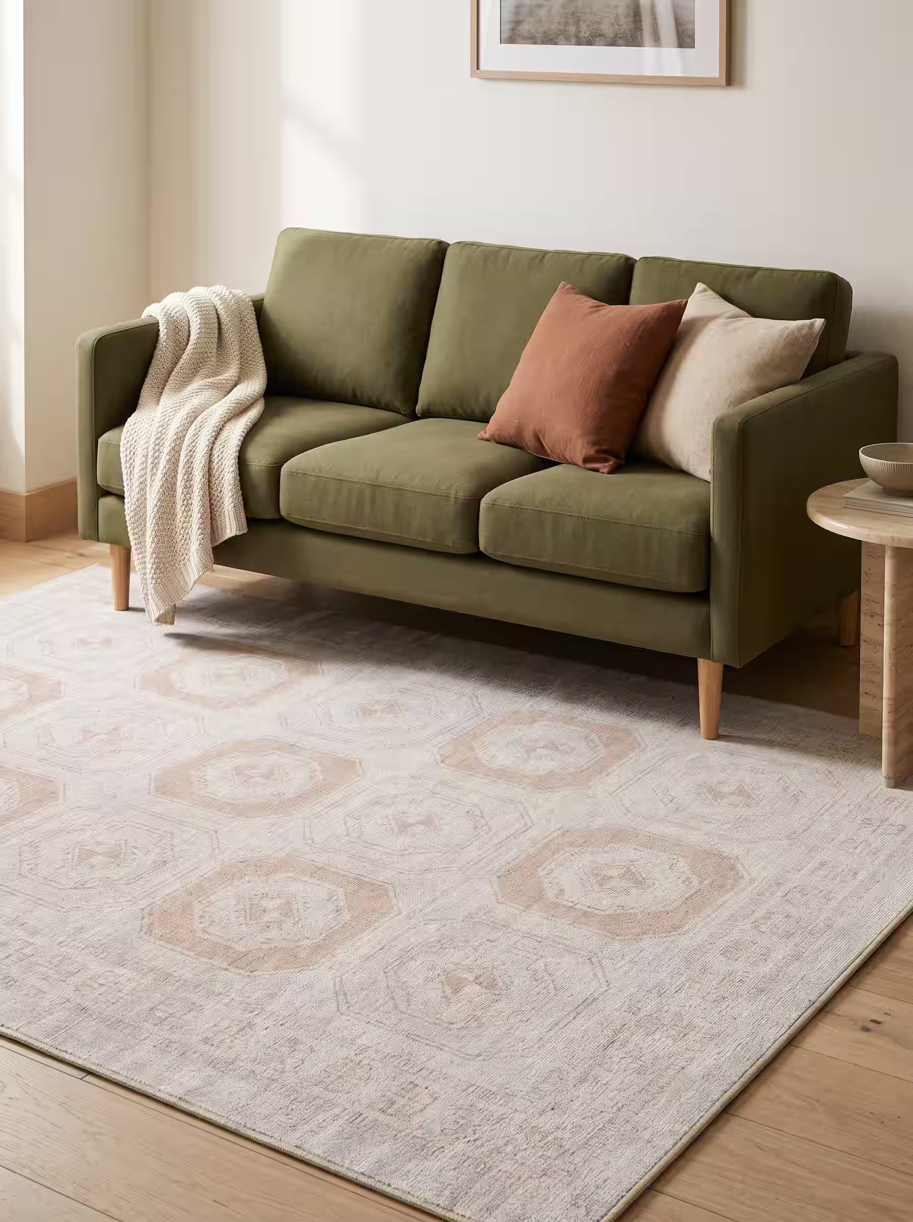 Cream and sand area rug paired with an olive green sofa in a modern living room