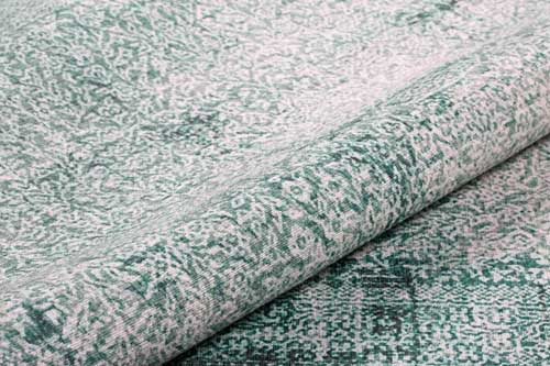 Close-up of textured fabric with a green and white pattern. Green Rugs - Fame Rugs.