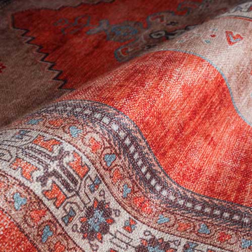 Close-up of a patterned rug with red, brown, and blue colors. Orange Rugs - Fame Rugs